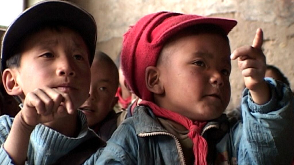 Tibetische Schulkinder blicken aufmerksam nach vorne.