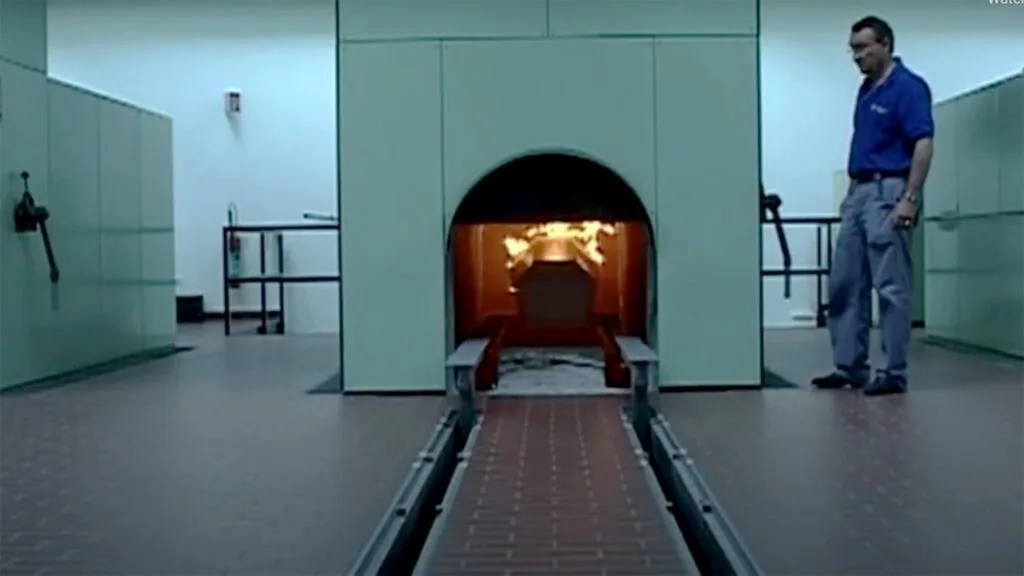 Cremation of a coffin in an incineration facility.