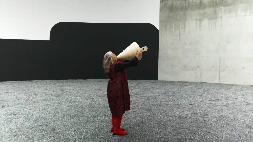 Corin Curschellas mit einem grossen Trichter in einem offenen Betonraum.